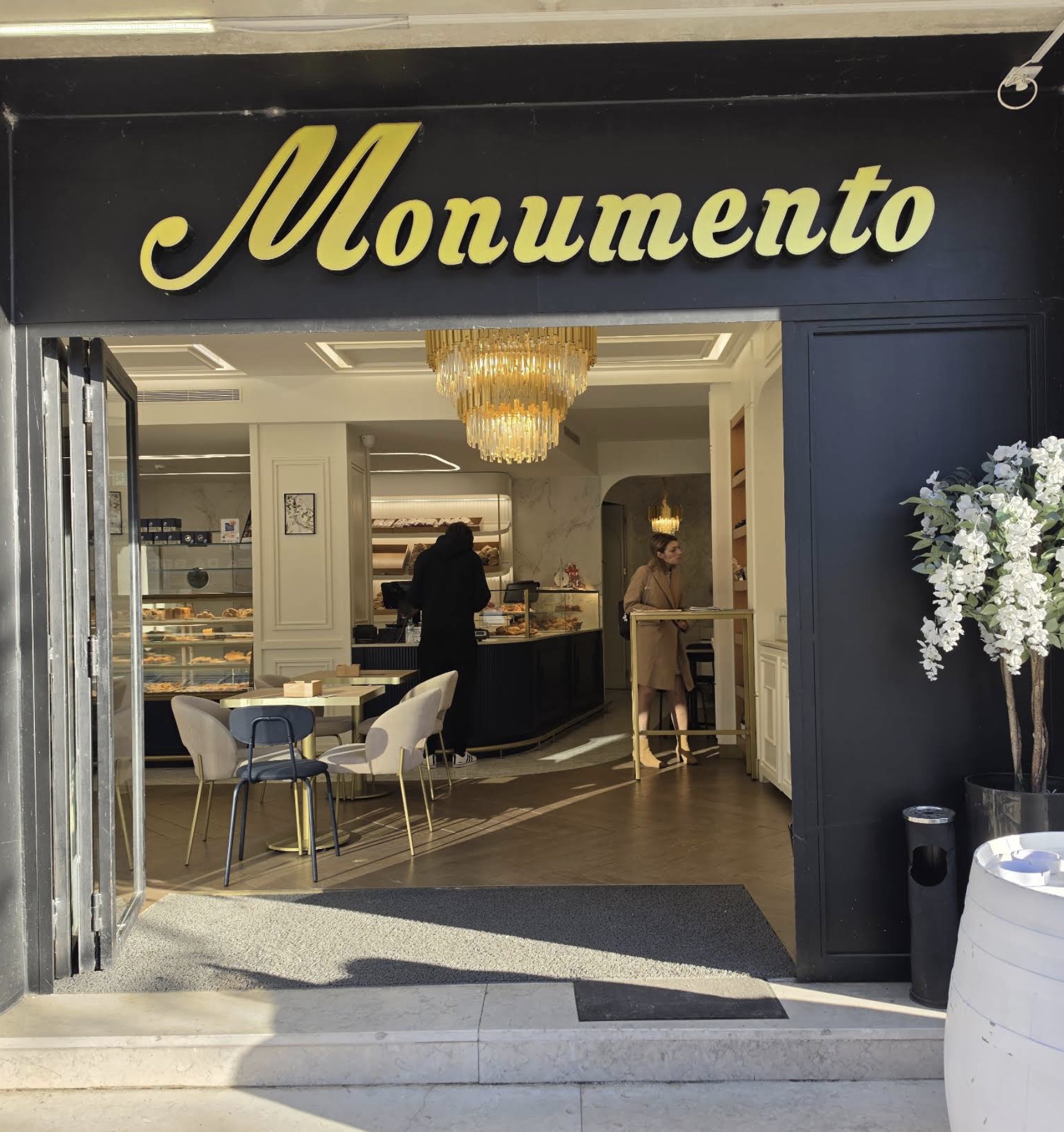 Entrada da Pastelaria Monumento, com o letreiro dourado e a sala à vista
